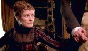 Fanny Dashwood, equally upset, holds onto her husband's hand.