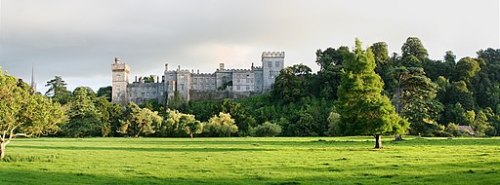 Image of Lismore Castle in a setting of trees and fields.